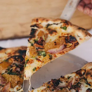 FLYIN&apos; HAWAIIAN PIZZA
Mozzarella, sliced gouda, honey pancetta, roasted pineapple with nutmeg and brown sugar, red onion, fresh basil.