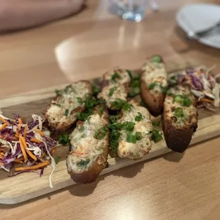 a wooden cutting board with a variety of appetizers on it
