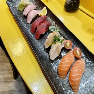 a long rectangular platter of different types of sushi