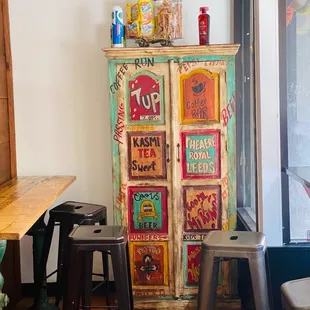 a colorful cabinet in the corner of a room