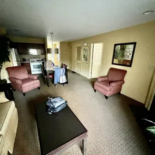 Sitting room, fireplace, tv, dining table, kitchen, hallway.