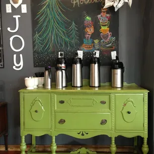 a green buffet with coffee pots on top