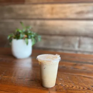 a cup of iced coffee on a wooden table