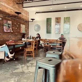 two people sitting at tables in a coffee shop
