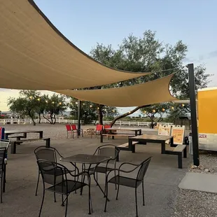 tables and chairs under a shade