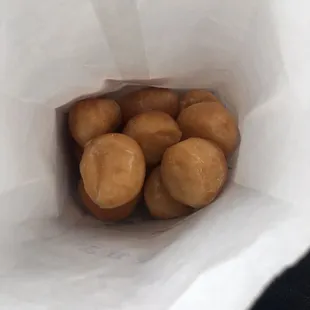 a white paper bag filled with doughnuts