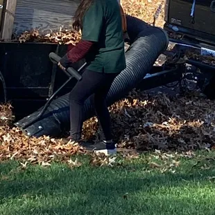 a woman sitting on a pile of leaves