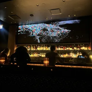 people sitting at a bar in a dark room