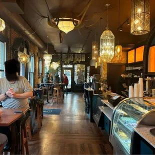 The entrance is welcoming, with a few covered tables and chairs outside the doors. The display cases are filled with DELICIOUS pastries.