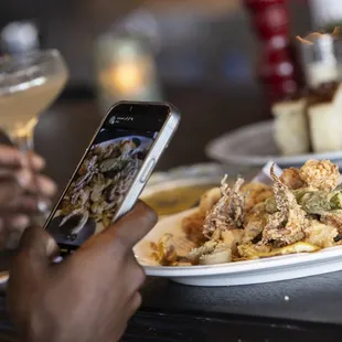 a person taking a picture of a plate of food
