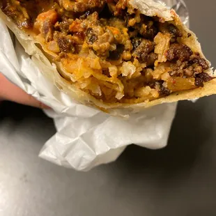 a hand holding a burrito