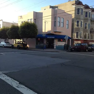a street corner with cars parked on the side of the road
