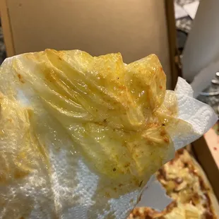 a hand holding a piece of pizza