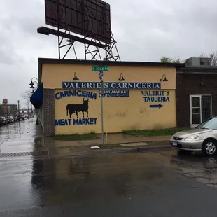 The carniceria on the corner, with sign pointing to the taqueria.