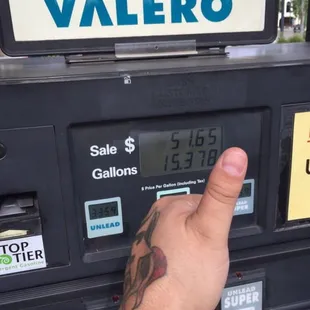 a hand pointing at a gas pump