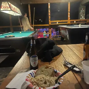 a pool table with a sandwich and beer