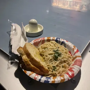 a plate of spaghetti and bread on a table
