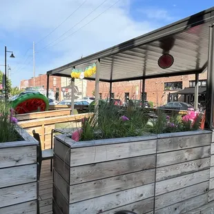 a wooden planter with flowers and umbrellas