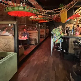 a view of a restaurant with tables and umbrellas hanging from the ceiling