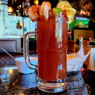a bloody drink with shrimp and garnish