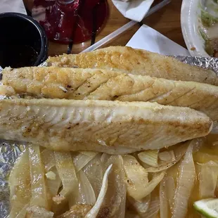 Grilled fish serving, minus one piece already consumed.