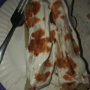 One pork and one chicken tamale with sour cream and hot sauce