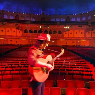 a man in a cowboy hat playing a guitar