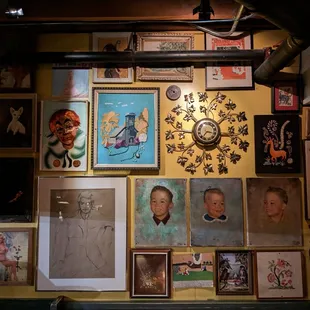 a wall full of portraits and a clock