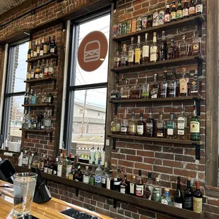 a brick wall with shelves filled with bottles of liquor