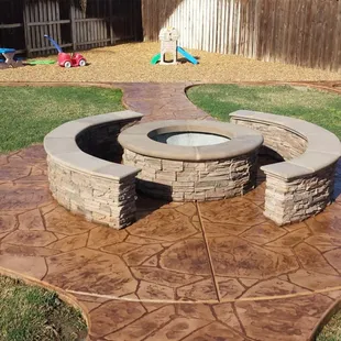 Fire pit on stamped concrete.  with culture stone and pre cast cap