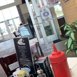 a table with a hot dog and condiments