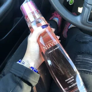 a person holding a bottle of nuvo