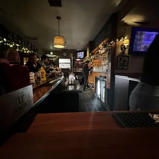 a bar with people sitting at the bar