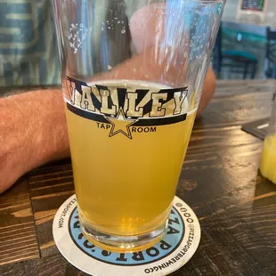 a glass of beer on a coaster
