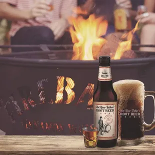 a glass of beer next to a fire pit