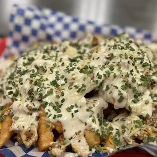 a plate of fries with cheese and herbs