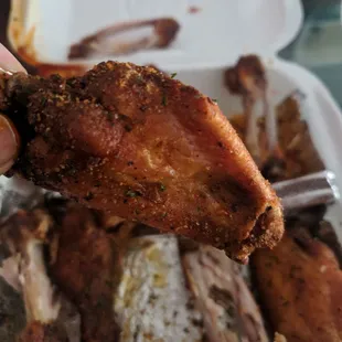 a hand holding a piece of chicken