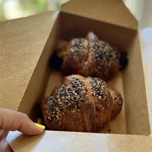 A pair of warmed up Broccolini and Three Cheese Croissants boxed to-go for a bike ride at the Big Creek Greenway.