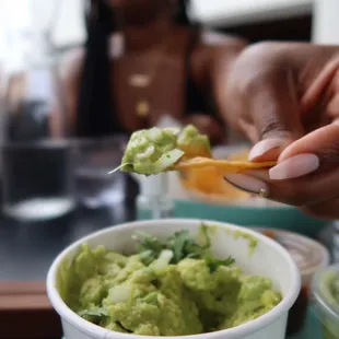 a woman eating guacamole at a restaurant