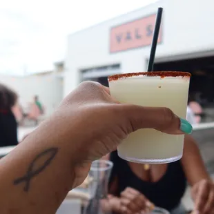 a person holding a drink with a straw in their hand