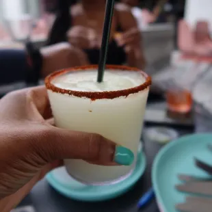 a person holding a drink with a straw