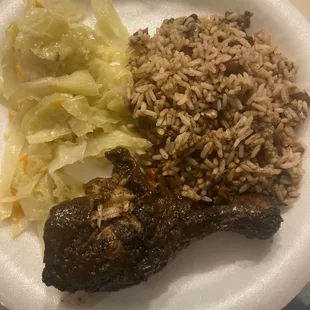 Jerk chicken, peas and rice with cabbage.