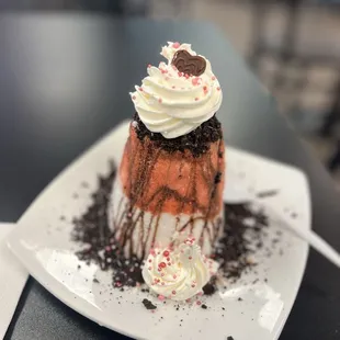 a chocolate cake with whipped cream and sprinkles