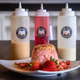 a strawberry ice cream sundae and two ketchup bottles