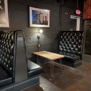 two black leather chairs and a small table