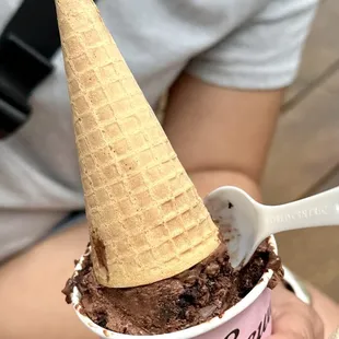 a person holding a cup of ice cream