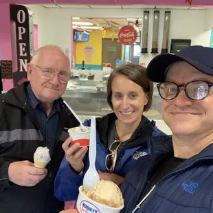 three people holding ice cream