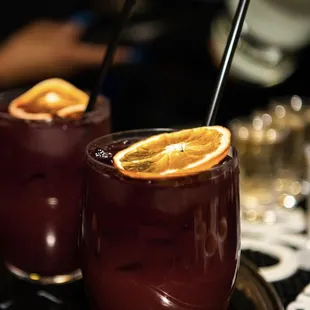 two glasses of wine with orange slices