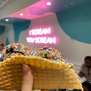 Cookies and cream and peanut butter chunk on a waffle taco with sprinkles