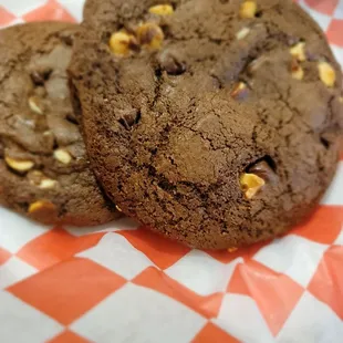 two chocolate cookies on a checkered paper